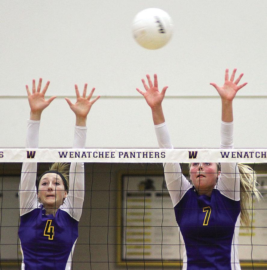 Junior Lauren Kaech and senior Kiana Black jump up as they block the ball from their opponents the Moses Lake Chiefs on Oct. 22.