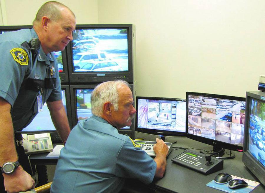 Safety and Security Director Bob King oversees Safety and Security Officer Don Durdens work on the Wenatchee High School camera monitors. 