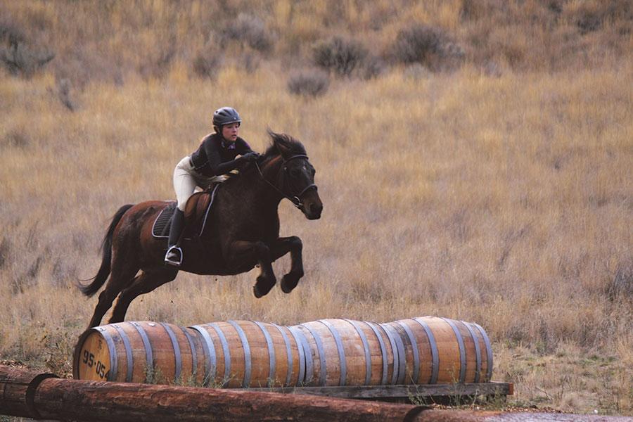 Senior Jessi Fore practices leaping over barrels with her horse, Kiana. “Kiana knows me just as well as any other person. It is such a surreal connection,” Fore said.
