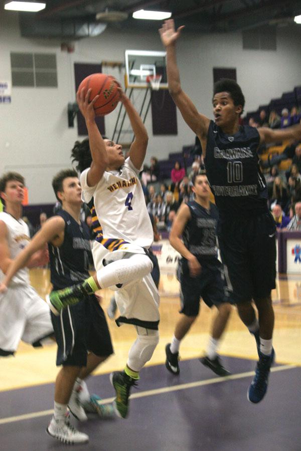 Sophomore Tony Esquivel attempts to shoot around a Chiawana defender at the home basketball game on Dec. 12. Wenatchee won 70-56. 