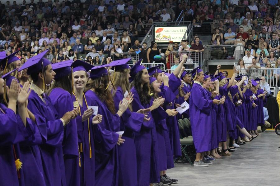 Seniors clap and raise their hands  rah! while singing the Wenatchee High School fight song during the graduation ceremony.